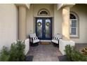 Charming front porch featuring double doors with decor, seating and manicured landscaping at 4721 Mainsail Drive, Bradenton, FL 34208