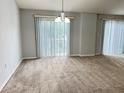 Spacious living room featuring neutral paint, carpet flooring, and sliding door access to the outdoor area at 6768 Breezy Palm Dr, Riverview, FL 33578