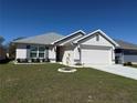 Well-maintained single-story home with green lawn, landscape features, and a two-car garage, ideal for Gathering at 2556 Averland Loop, North Port, FL 34287