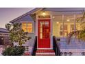 Quaint home featuring a bright red front door, complemented by neat landscaping and exterior lighting at 310 S Osprey Ave, Sarasota, FL 34236