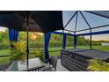 Private backyard patio featuring a hot tub, patio set, lush landscaping, and outdoor curtains at 4221 Park Willow Ave, Palmetto, FL 34221