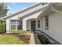 Inviting front entrance with a screened front door, lush landscaping, and a well-maintained walkway at 4528 Fern Dr, Bradenton, FL 34208