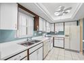 Bright kitchen featuring white appliances, ample cabinet space, and tiled floors at 6205 Green View Dr # 129, Sarasota, FL 34231