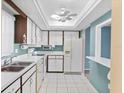 Bright kitchen featuring white appliances, ample cabinet space, and tiled floors at 6205 Green View Dr # 129, Sarasota, FL 34231