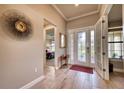 Bright foyer features wood-look tile floors, a decorative mirror, and a glass front door at 7760 Grande Shores Dr, Sarasota, FL 34240