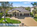 Beautiful home featuring a well-maintained lawn, mature trees, and a spacious driveway leading to a three-car garage at 12810 Daisy Pl, Bradenton, FL 34212