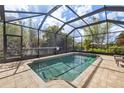 Relaxing screened-in pool with brick patio and lush landscaping provides a private outdoor oasis at 12810 Daisy Pl, Bradenton, FL 34212