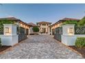 Beautiful home featuring a well manicured lawn, manicured shrubs, and a brick driveway at 14733 Como Cir, Lakewood Ranch, FL 34202