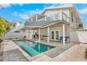 Backyard featuring a pool with a patio, awning, balcony, and fenced yard at 264 S Harbor Dr, Holmes Beach, FL 34217