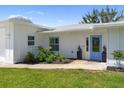 Well-maintained home featuring a blue door, manicured lawn, and fresh landscaping at 400 Dona Dr, Nokomis, FL 34275