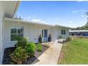 Charming single-story home with a manicured lawn, attractive landscaping, and a welcoming blue front door at 400 Dona Dr, Nokomis, FL 34275