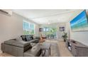 A spacious living room with a comfortable sectional sofa, a ceiling fan and sliding glass doors to the exterior balcony at 4207 Marina View Way, Cortez, FL 34215