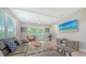 A spacious living room with a comfortable sectional sofa, a ceiling fan and sliding glass doors to the exterior balcony at 4207 Marina View Way, Cortez, FL 34215