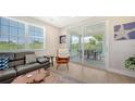 A spacious living room with a comfortable sectional sofa, a ceiling fan and sliding glass doors to the exterior balcony at 4207 Marina View Way, Cortez, FL 34215