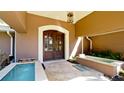 Inviting home entrance featuring an arched entryway, double doors and a courtyard pool at 542 67Th St, Holmes Beach, FL 34217