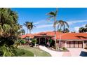 Beautiful home exterior featuring a tile roof, double garage, lush landscaping, and a well-manicured lawn at 542 67Th St, Holmes Beach, FL 34217