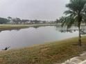 Scenic view of a tranquil lake surrounded by lush greenery and community homes on a cloudy day at 7211 W Country Club N Dr # 135, Sarasota, FL 34243