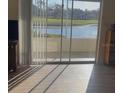 Bright interior shot showcasing the serene lake view through sliding glass doors leading to the outdoor living space at 7211 W Country Club N Dr # 135, Sarasota, FL 34243