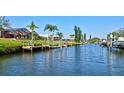 Waterfront view of canal with private boat docks with tropical landscaping in a residential neighborhood on a sunny day at 104 Inlets Blvd # 104, Nokomis, FL 34275