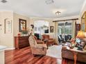 Cozy living room with hardwood floors, comfortable seating, and a view of the outdoor living space at 13811 Nighthawk Ter, Lakewood Ranch, FL 34202