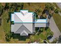 A bird's-eye view of a single-story home showcasing its roof, landscaping, and adjacent carport at 276 Cerromar Way # 60, Venice, FL 34293