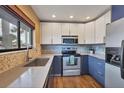 Updated kitchen featuring modern two-tone cabinetry, stainless steel appliances, mosaic backsplash, and hardwood flooring at 3500 El Conquistador Pkwy # 336, Bradenton, FL 34210