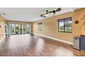 Spacious living room with hardwood floors, neutral paint, ceiling fan, and large sliding glass doors to outdoor patio at 3500 El Conquistador Pkwy # 336, Bradenton, FL 34210