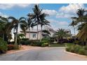 Beautifully landscaped home with tropical plants and a metal roof, set against a cloudy sky at 741 Hideaway Bay Dr, Longboat Key, FL 34228