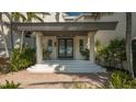 Inviting front entrance with double doors, columns, and well-manicured landscaping at 741 Hideaway Bay Dr, Longboat Key, FL 34228