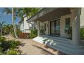 Elegant front entrance with double doors, white columns, and a brick walkway surrounded by greenery at 741 Hideaway Bay Dr, Longboat Key, FL 34228
