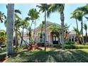 Charming single-story home boasts lush landscaping and swaying palms, creating a tranquil tropical oasis at 1007 3Rd E St, Palmetto, FL 34221
