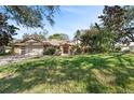 Charming single story home with mature trees and a lush green front lawn at 1612 Pine Harrier Cir, Sarasota, FL 34231