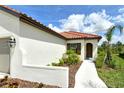 This cozy, single-story home features a red tile roof, neutral stucco, and an inviting walkway at 309 Potenza Loop, Nokomis, FL 34275