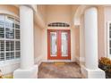 The front entrance has a brick paver entry, stately columns, and a bright red double-door at 4245 Corso Venetia Blvd, Venice, FL 34293