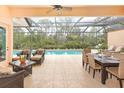 This covered patio has ample seating, an outdoor dining area, and views of the backyard pool at 4245 Corso Venetia Blvd, Venice, FL 34293