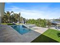 Gorgeous pool and spa with lush landscaping, a boat, and turf at 504 Bayview Dr, Holmes Beach, FL 34217