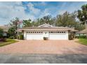 Inviting home showcasing a brick driveway and spacious two-car garage, ideal for comfortable parking at 5642 Garden Lakes Dr, Bradenton, FL 34203
