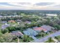 A scenic aerial view showcasing a home nestled among lush greenery, a lake, and a golf course at 6612 Saint James Xing, University Park, FL 34201