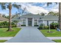 Stunning home showcasing a meticulous lawn, mature landscaping, and a grand paver driveway at 6612 Saint James Xing, University Park, FL 34201