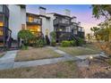 A townhome with rear wooden decks and stairs, a grassy area, and tropical landscaping at 6790 Sarasea Cir # 6790, Sarasota, FL 34242