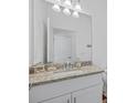 Bathroom vanity with granite countertop and a large mirror, offering a clean design at 2081 Gardenia Ave, Port Charlotte, FL 33953