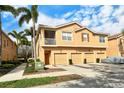 Attractive townhome featuring a stucco facade, three garages, and tropical palm tree landscaping at 3823 Parkridge Cir # 1-101, Sarasota, FL 34243