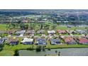 Stunning aerial view of the home with a pool, a lake, and a golf course in the background at 3837 Torrey Pines Blvd, Sarasota, FL 34238