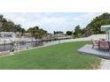 Green backyard featuring a dock, boat lift, and outdoor patio space, ideal for relaxation and entertaining with waterfront access at 408 Bryn Mawr Is, Bradenton, FL 34207