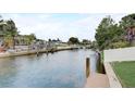 Wide canal view with seawall and docks extending toward waterfront homes and palm trees in a waterfront community at 408 Bryn Mawr Is, Bradenton, FL 34207