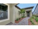A covered entrance featuring pavers and lush landscaping at 428 Bocelli Dr, North Venice, FL 34275