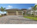 Charming single-Gathering home featuring a two-car garage, tile roof, and a beautifully paved driveway at 428 Bocelli Dr, North Venice, FL 34275