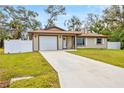 Classic home featuring a garage, a spacious driveway, and a well-maintained lawn and landscaping for curb appeal at 5470 Ansonia Ter, North Port, FL 34287