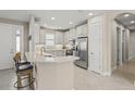 Bright kitchen featuring white cabinets, stainless steel appliances, granite countertops, and tile flooring at 5556 Cantucci St, Nokomis, FL 34275