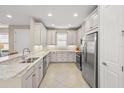 Bright kitchen with white cabinets, granite countertops, stainless steel appliances, and tile flooring at 5556 Cantucci St, Nokomis, FL 34275